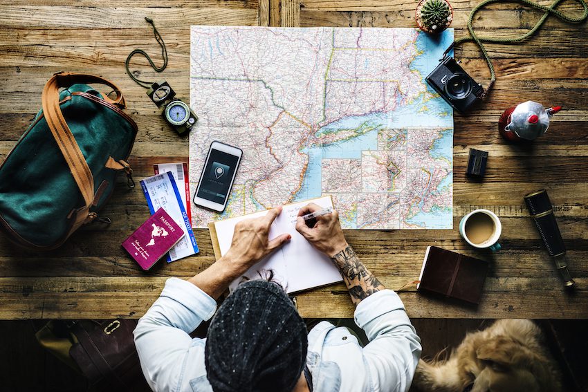 Man with map , camera, passport and compass